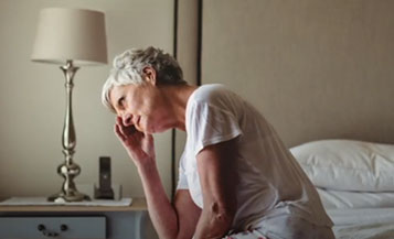 woman sitting on a bed, tired